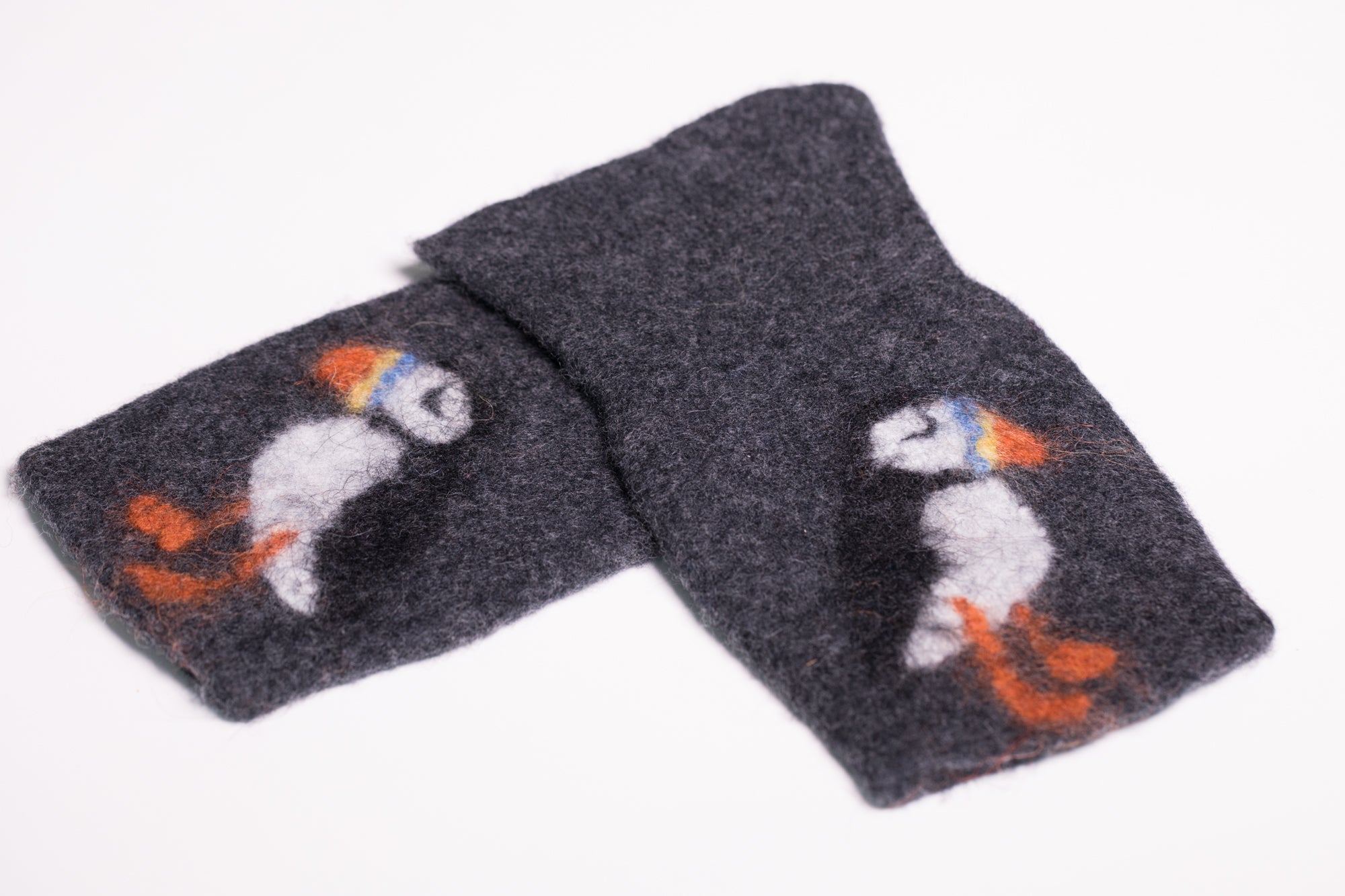 Warm and soft fingerless half mittens with a hand felted little puffin. Colour charcoal.